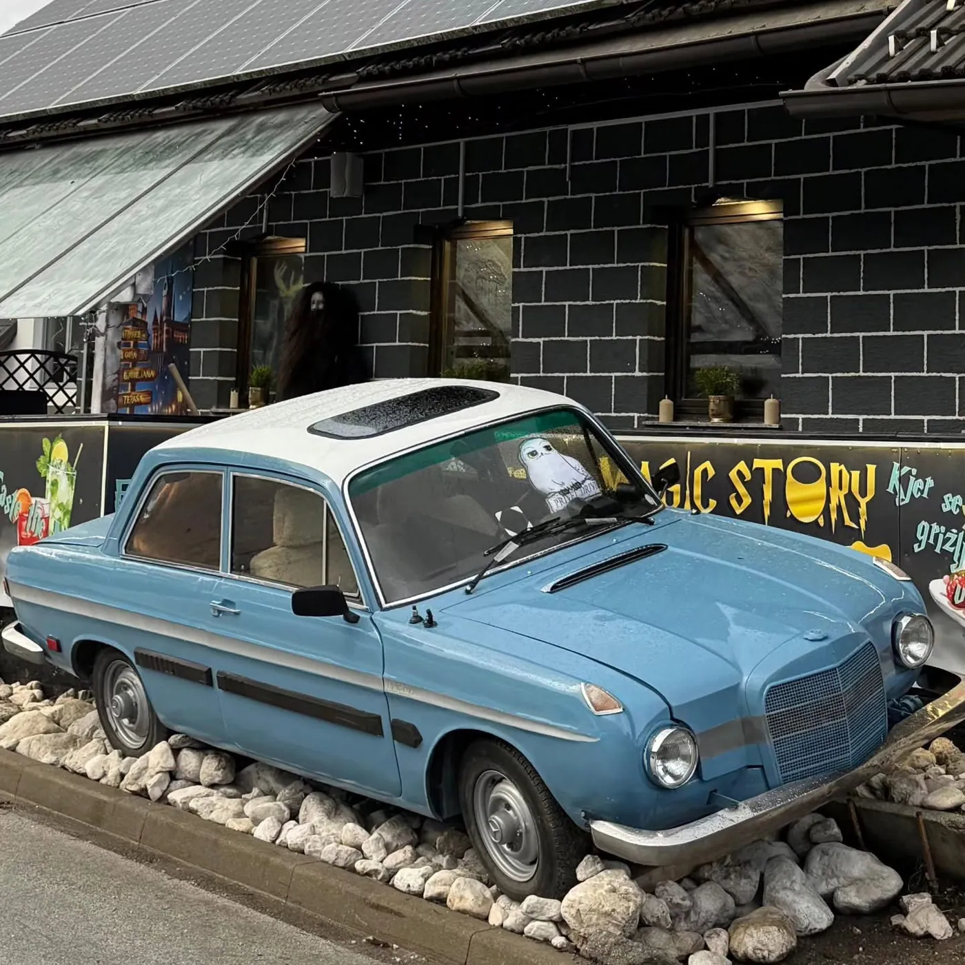 Blauer fliegender Wagen vor dem Eingang des Restaurants Magic Story